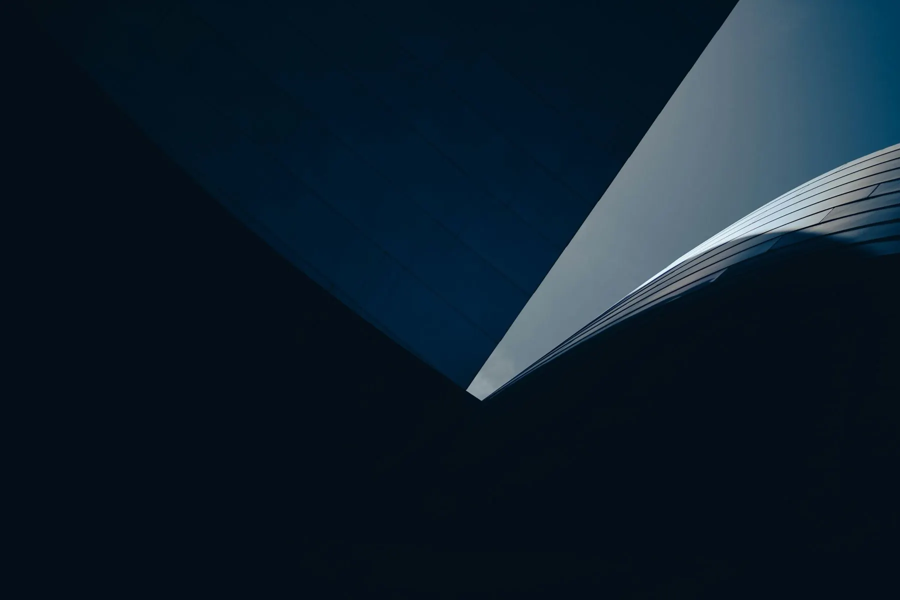 Curved modern building against a dark night sky