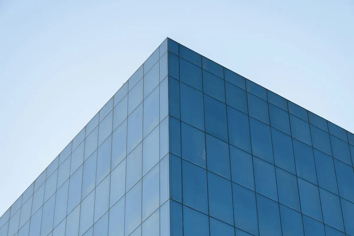Corner of a glass office building against a clear sky