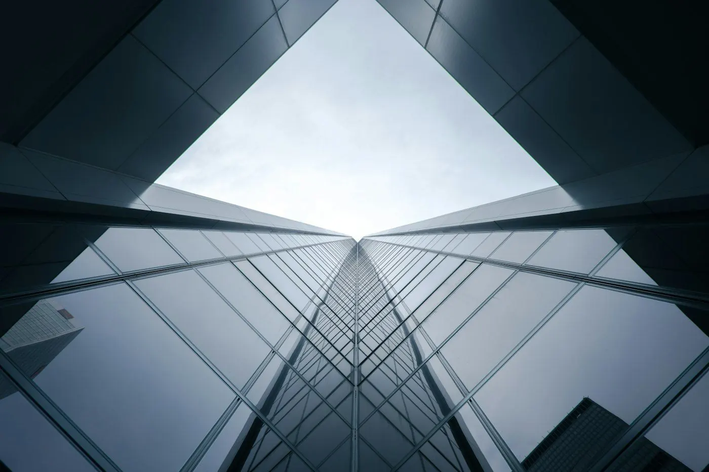 Glass office towers converging toward the sky, seen from below